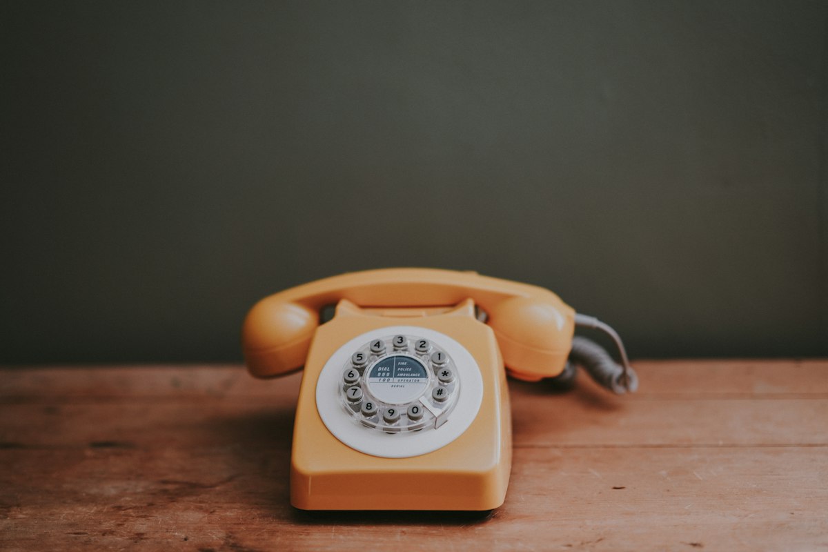 Telefono a disco marrone in una stanza dalle pareti grigie