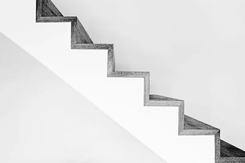 Scala in cemento bianco con ringhiere nere in forte contrasto