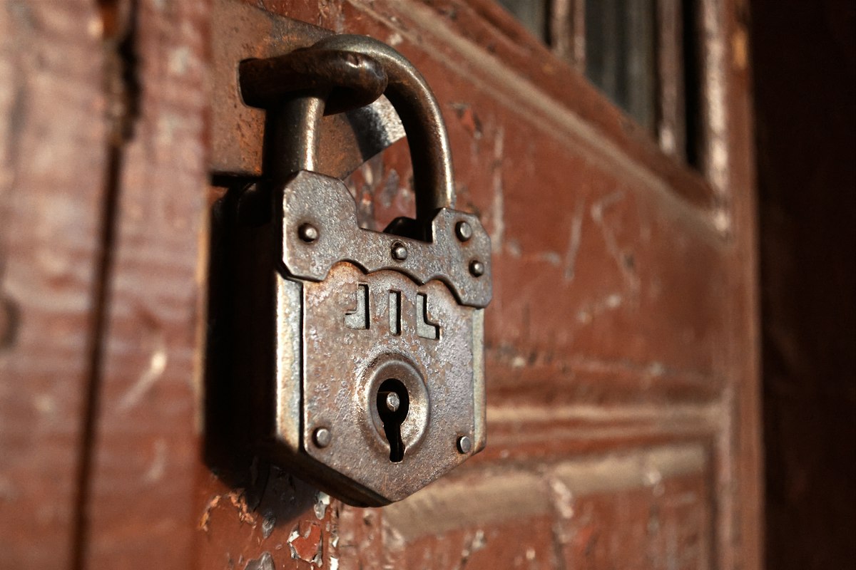 Vecchio lucchetto arrugginito su una porta di legno
