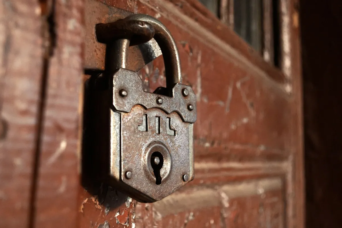 Vecchio lucchetto arrugginito su una porta di legno
