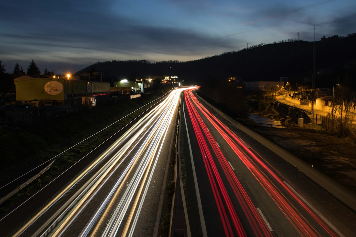 Scie di luce dei fari delle auto lungo un'autostrada di notte